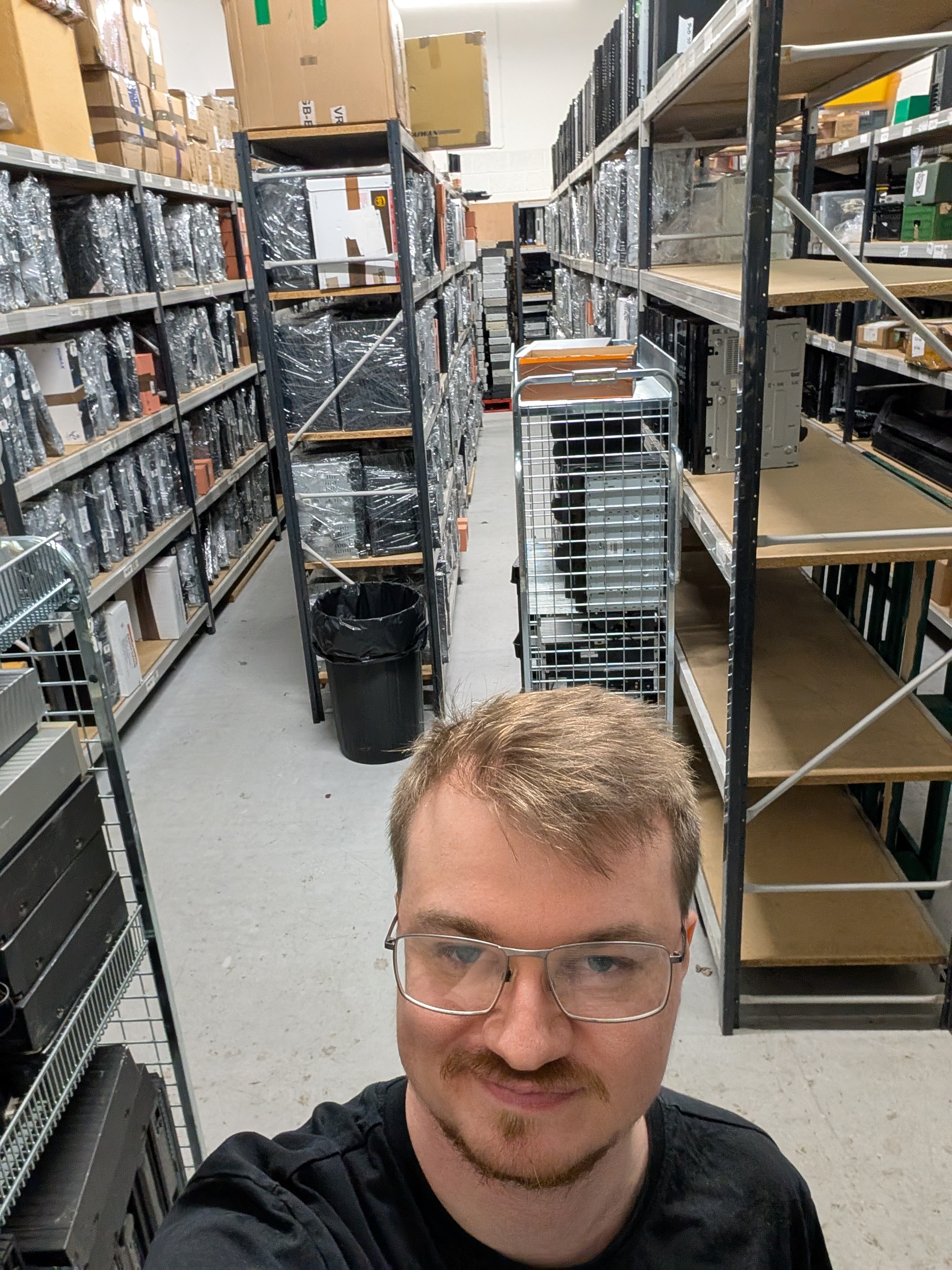 Jack in the Continue Technology warehouse, surrounded by shelves of computers and stock